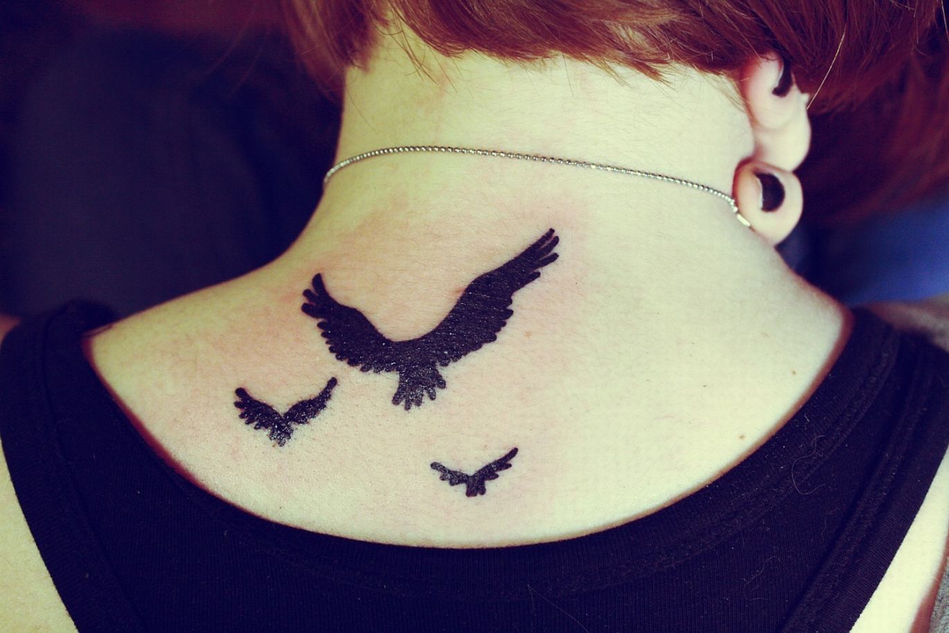 Татуировка птицы на шее
