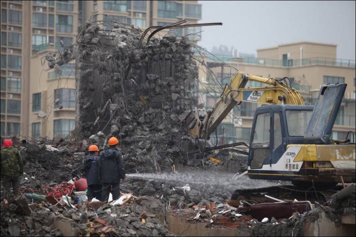 Как китайские рабочие сносят жилой дом (3 фото)