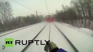 Молодые парни прицепились к поезду и катаются на лыжах